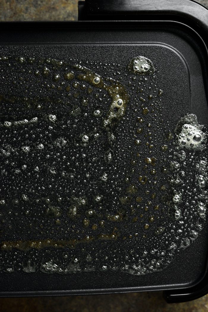 butter a preheated griddle