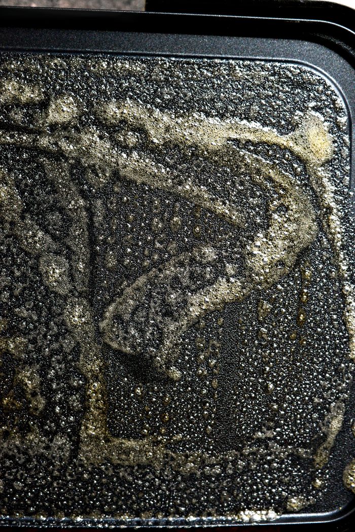 butter a preheated griddle