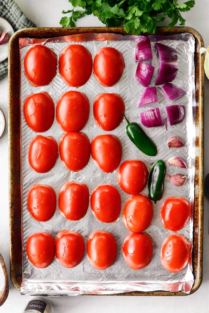 add tomatoes, red onion, jalapeño and garlic. drizzle with oil