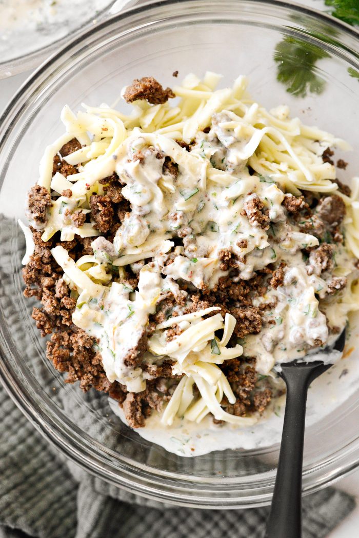 to the bowl with the ground beef add some cheese and sauce