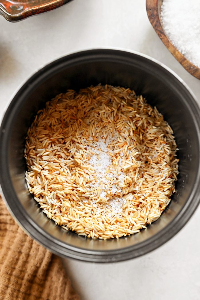 transfer toasted rice to rice cooker and add salt